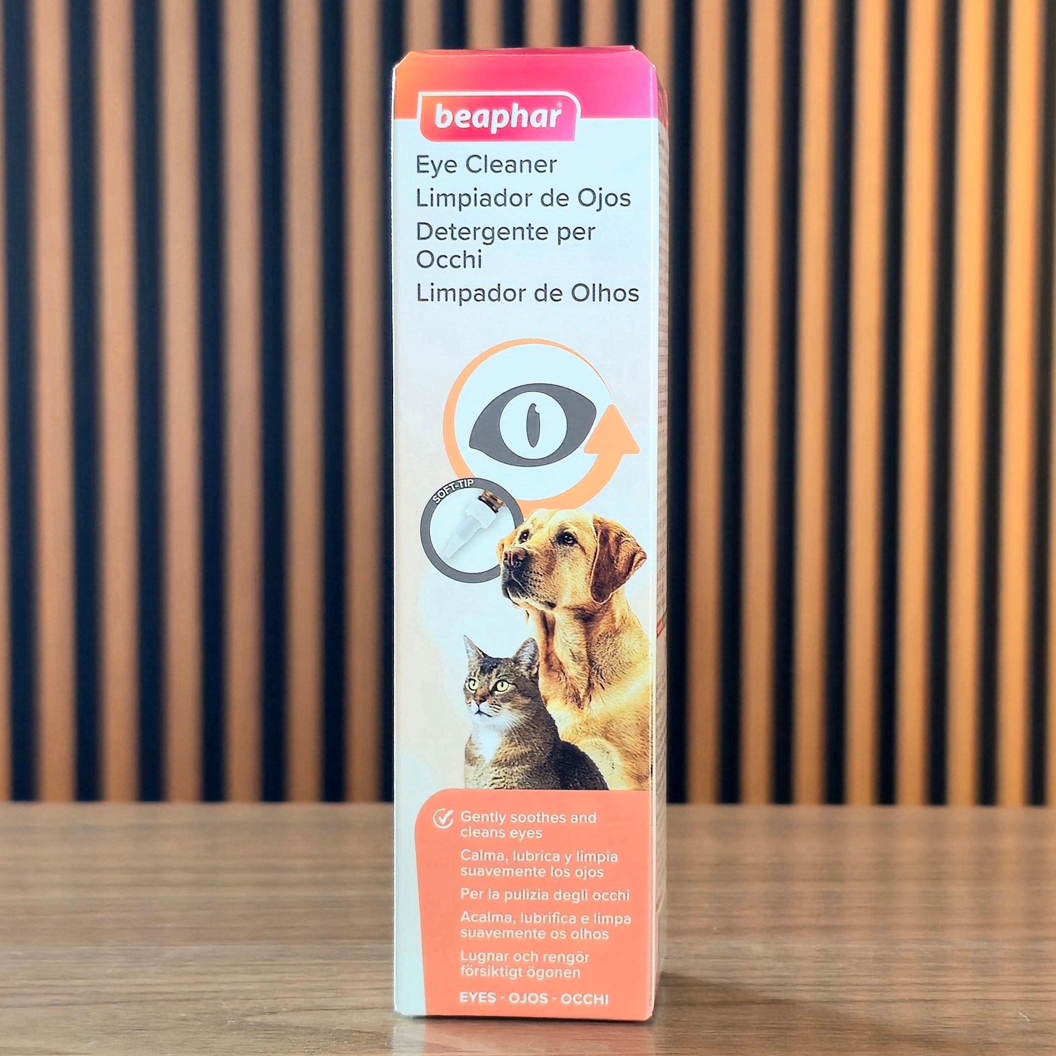 Beaphar Eye Cleaner box for pets, featuring a dog and cat illustration, standing on a wooden surface against a wooden slatted background.