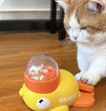 Load image into Gallery viewer, A duck-shaped interactive treat dispenser with a transparent dome on top, filled with treats. A cat is looking at the dispenser with interest.

